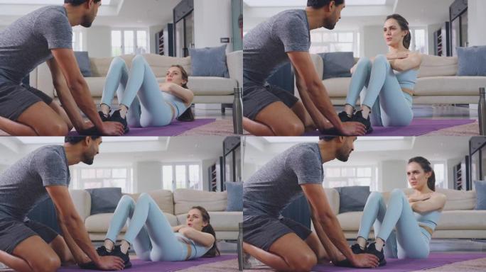与男性私人教练一起做仰卧起坐作为在家锻炼的一部分的女人