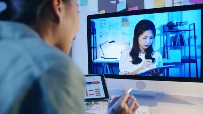 亚洲女商人使用桌面与同事谈论客厅视频通话会议的计划。