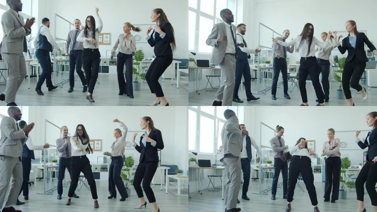 在办公室的团队建设派对上，漂亮的亚洲女人与同事跳舞