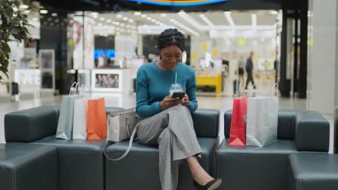 女人使用智能手机并在购物后休息