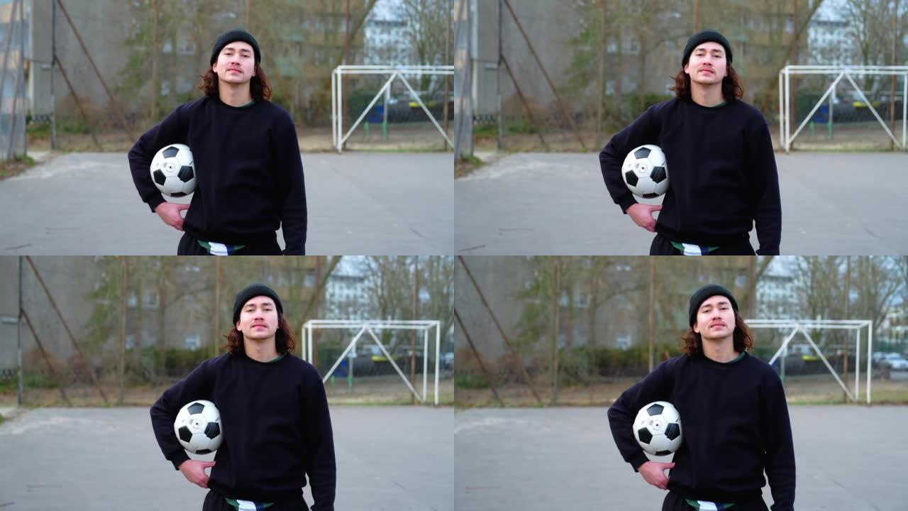 一个自信的年轻人在运动场上踢足球的肖像