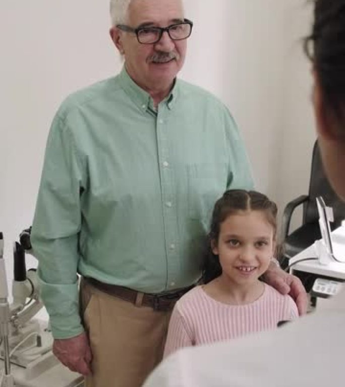与爷爷在眼科医生约会的小女孩
