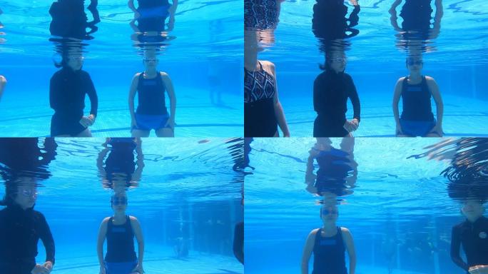 亚洲华人游泳在游泳池里练习在水下呼吸，用鼻子吹空气