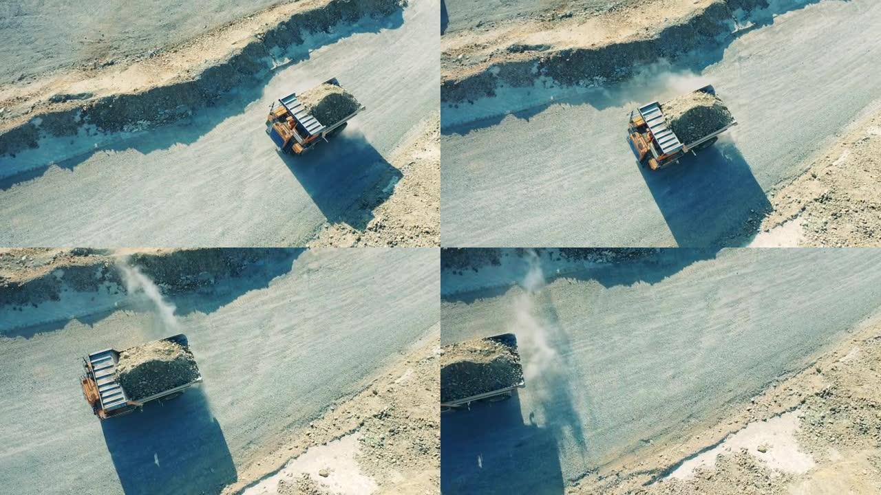 一辆满载卡车穿越露天矿井的俯视图。采石场、露天采矿、矿石开采概念。