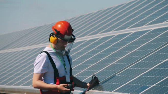 维修人员正在检查太阳能电池板的张力。可再生能源、太阳能发电厂、绿色电力概念。