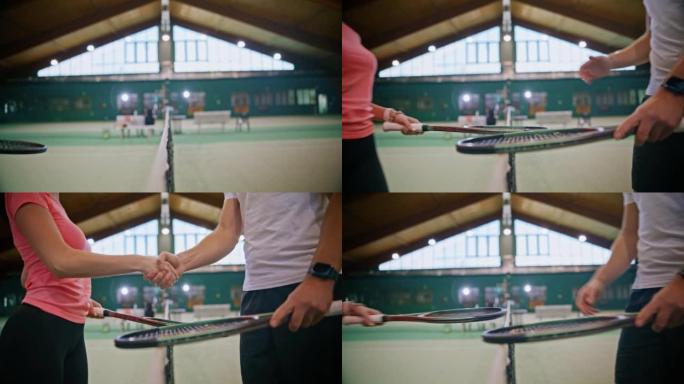 年轻的男教练和妇女在网球网上在球场上握手