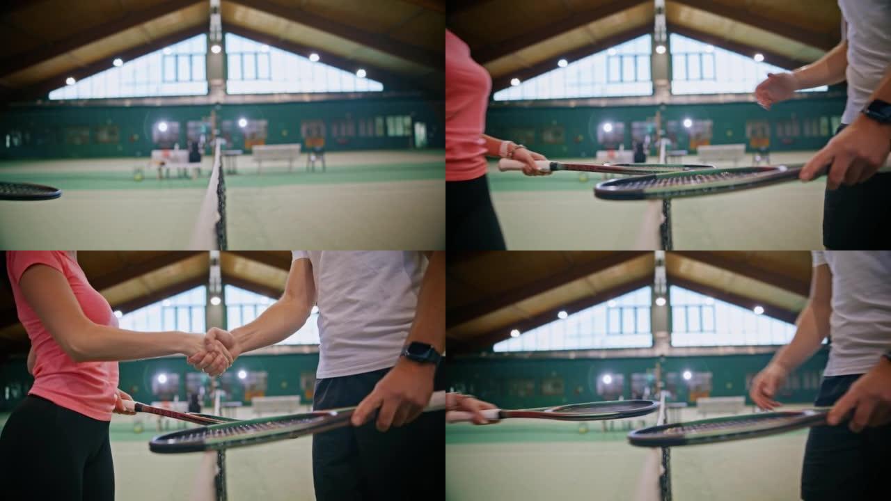 年轻的男教练和妇女在网球网上在球场上握手
