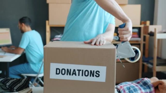 在慈善公司工作的统一包装捐款箱中的志愿者特写