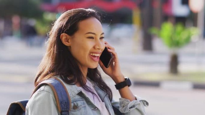 亚洲女性在智能手机上聊天并微笑