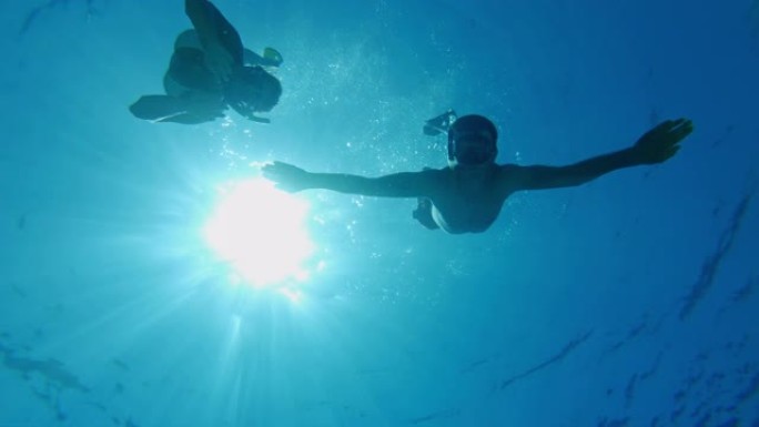 女士夫妇在克罗地亚亚得里亚海阳光明媚的蓝色海洋中浮潜
