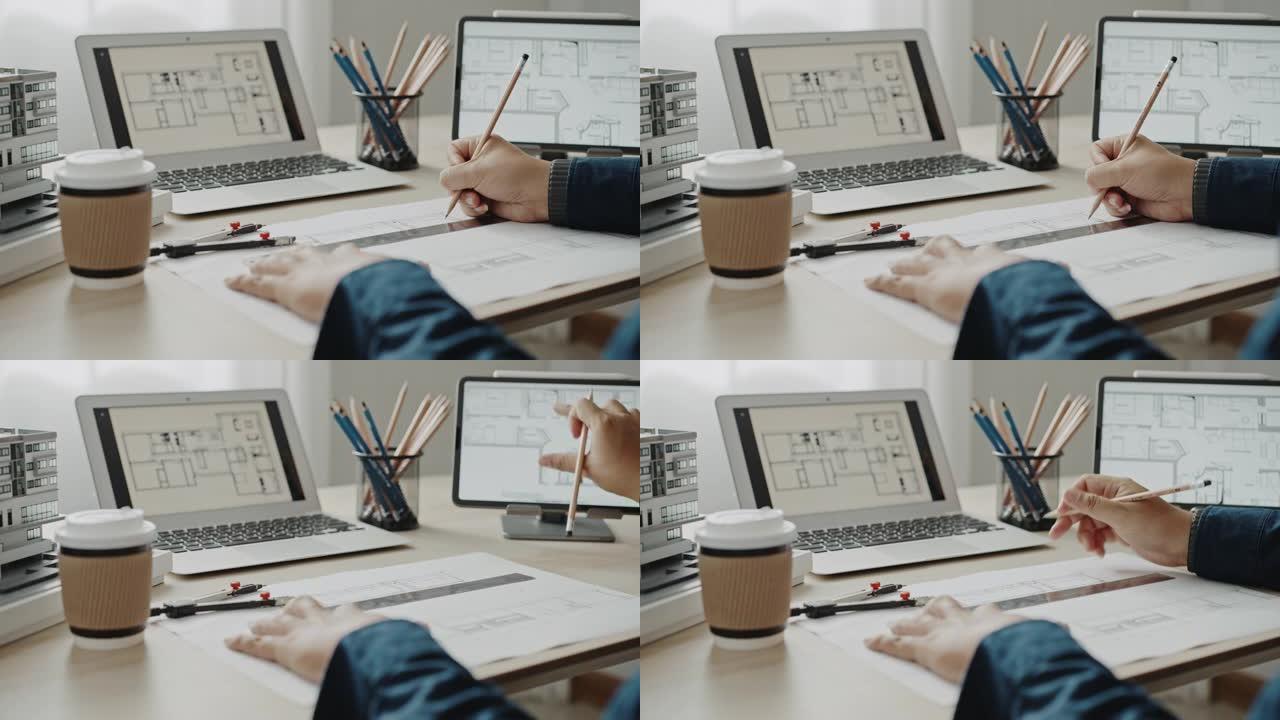建筑师拿着铅笔与笔记本电脑和建筑平面图一起工作
