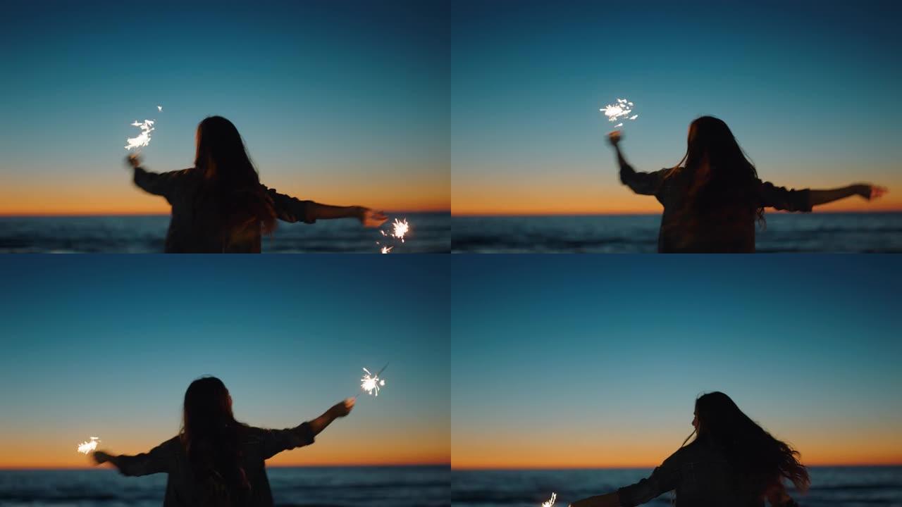 日落时在海滩上与烟火共舞的女人庆祝除夕女孩在海边享受独立日庆祝活动