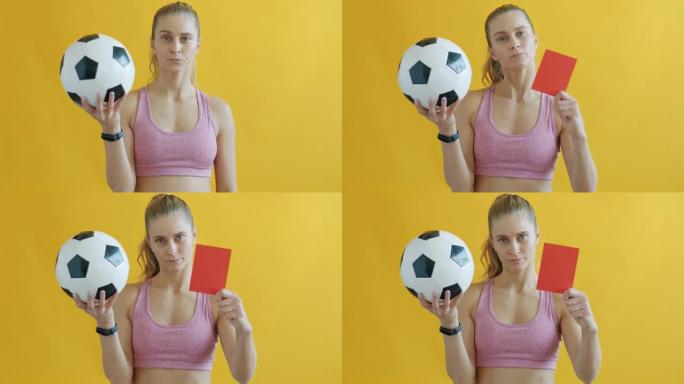 年轻的女运动员拿着足球的肖像，出示红牌并看着相机