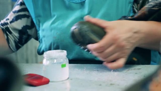 女工在制造过程中将胶水涂在靴子上