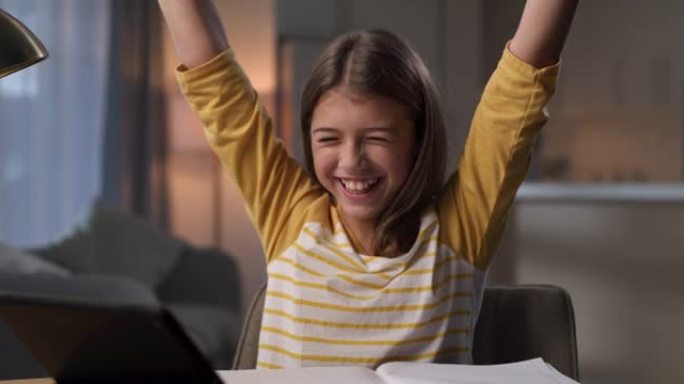 4k视频片段，一个年轻女孩在家里做作业时庆祝成就