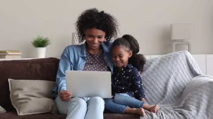 非洲母亲5s女儿在笔记本电脑上观看动画片时笑