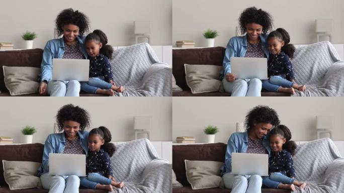 非洲母亲5s女儿在笔记本电脑上观看动画片时笑
