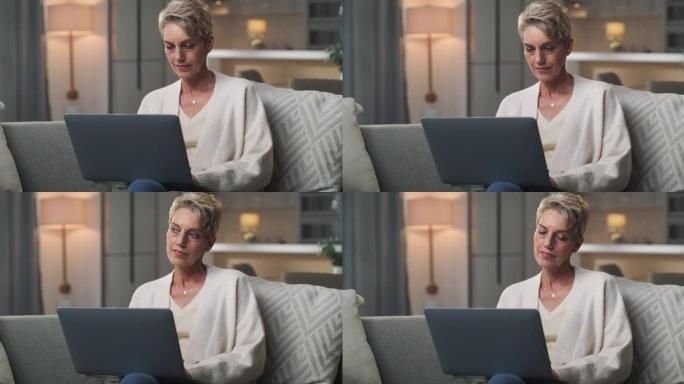 一名高级妇女坐在家里使用笔记本电脑的4k视频片段
