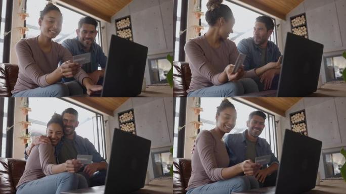 幸福的多元化夫妇在家，女人在网上用信用卡购买东西，然后拥抱她的男朋友时看起来非常兴奋