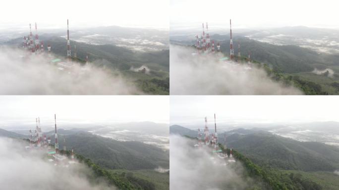 飞行无人机的鸟瞰图，具有4g和5g电信塔通信基站和天线的视差运动，在山顶上，禁食的云雾笼罩着泰国的绿