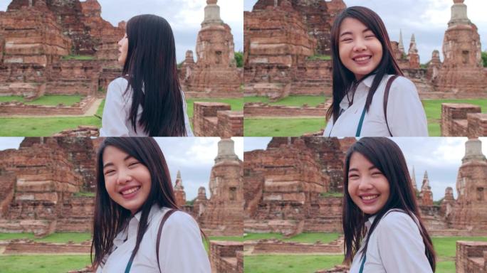 开朗美丽的年轻亚洲背包客博客写手女人随手拍照，微笑着在老城区的宝塔旅行。