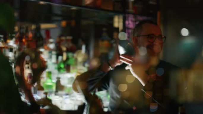 专业调酒师的特写镜头是在酒吧或迪斯科俱乐部向顾客混合酒精鸡尾酒和冰块。