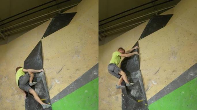 垂直: 年轻人仅使用黑色体积杆爬上人造墙。