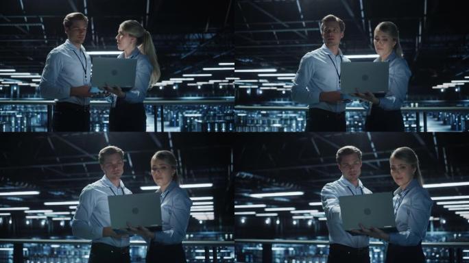 数据中心女性电子商务企业家和男性IT专家交谈，使用笔记本电脑。桥梁上的两名信息技术专业人员俯瞰着大型
