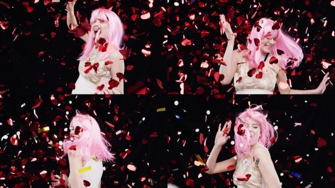 4k视频片段，一名年轻女子在工作室背景下戴着粉红色假发跳舞
