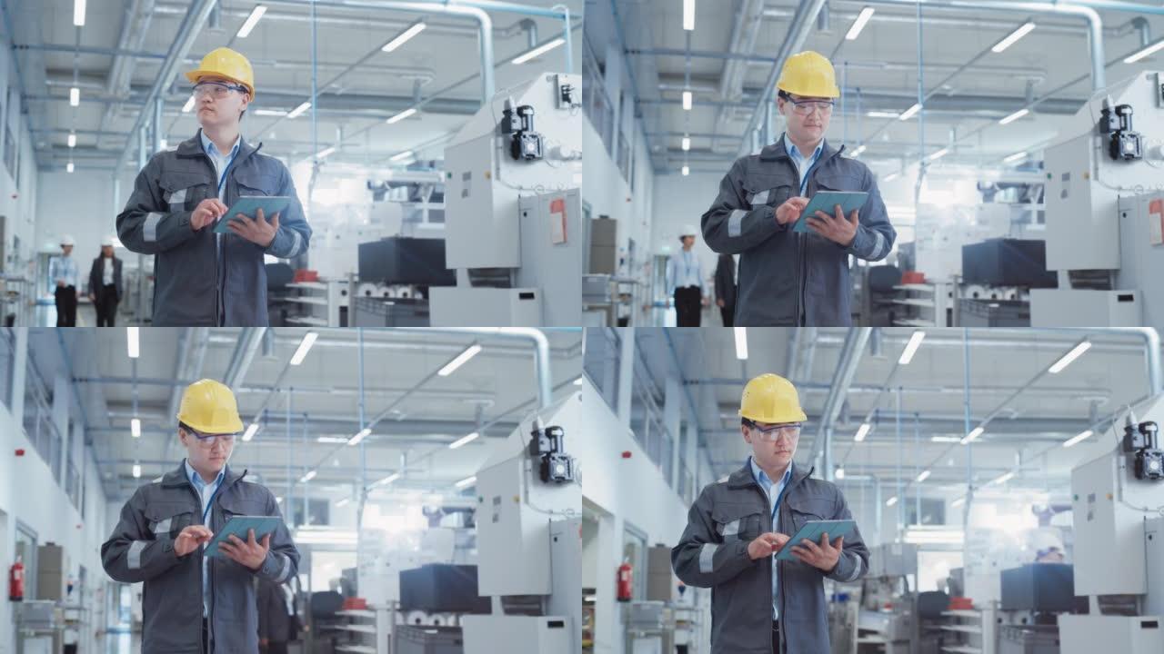 一个年轻的亚洲男子的肖像，在工厂里当工程师，穿着工作衣和黄色安全帽。从事平板电脑工作的重工业专家。