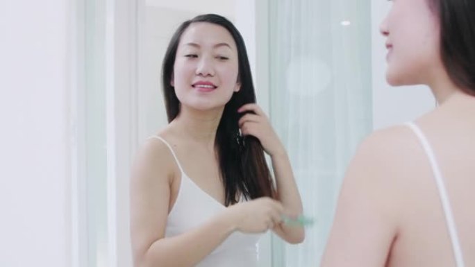 美丽的亚洲女人在家洗完澡后梳头