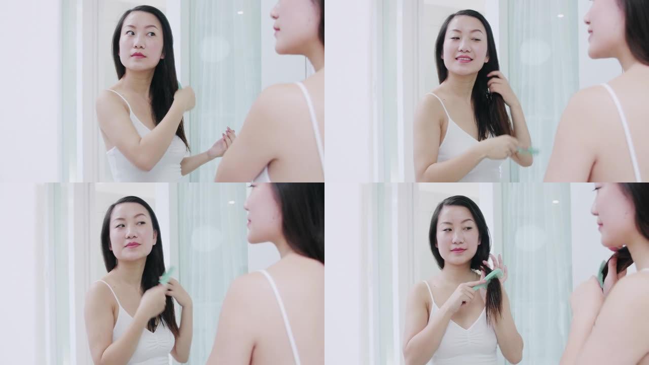 美丽的亚洲女人在家洗完澡后梳头
