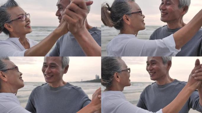 69-70岁的亚洲老年夫妇手牵着手，在沙滩上沿着日落的边缘一起跳舞。老年夫妇在海边放松。老年假期。非