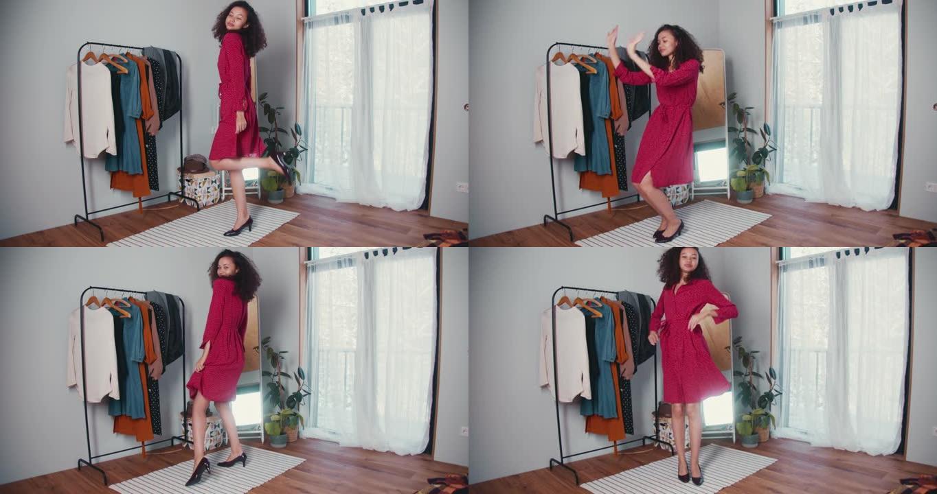迷人的年轻快乐的非裔美国时尚博主女人看着相机穿着新鞋摆姿势，镜子上的红色连衣裙