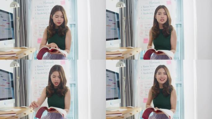 亚洲年轻女英语教师视频会议看着摄像头说话，通过摄像头学习教学，在网上聊天在家。