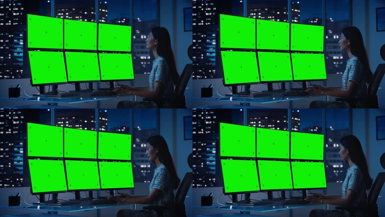 财务分析师在带有多显示器工作站的计算机上工作，显示屏上带有绿屏色度键模拟模板。女商人在傍晚在投资银行