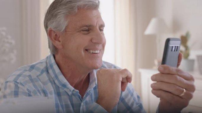 快乐的成熟男人使用智能手机进行视频聊天祖父向婴儿挥手，喜欢在手机4k镜头上与孙子聊天