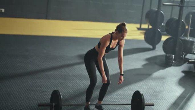 尝试女性在健身房健身训练与杠铃为健美目标，肌肉动力或健康，健康的生活方式。年轻人在地板或地面上放松以