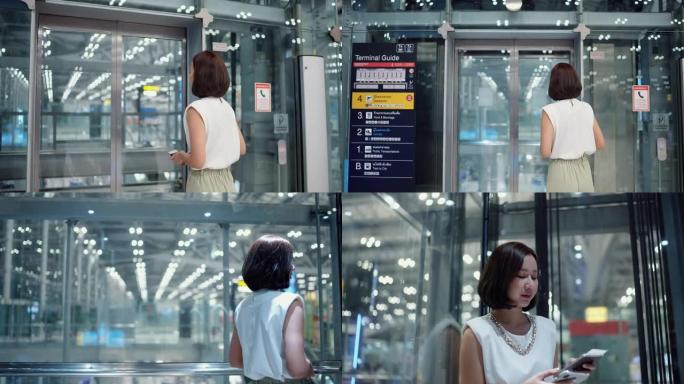 迷人的女人拿着智能手机和护照坐在透明电梯里