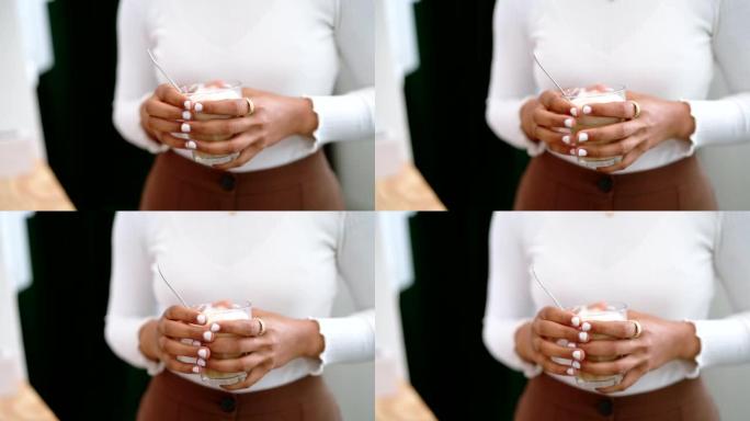 休息时，一名妇女拿着咖啡杯与同事交谈的特写镜头