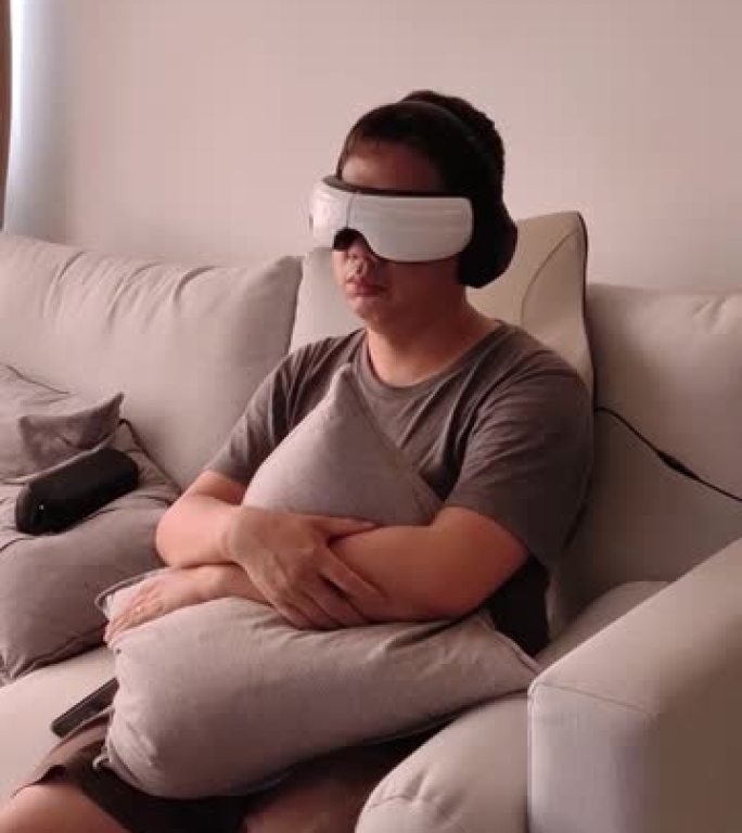 亚洲中国中年男子放松享受虚拟现实在线电影使用虚拟现实谷歌在客厅坐在沙发上