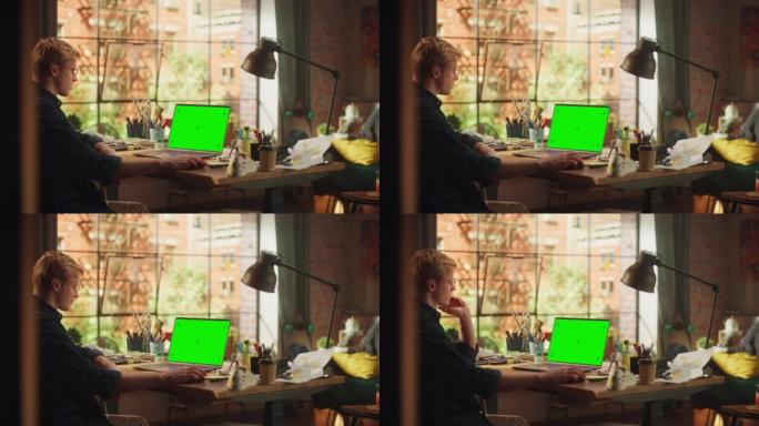 在Loft Modern Place从事带有绿屏模型显示的台式计算机的男性专家。十几岁的自由职业者用