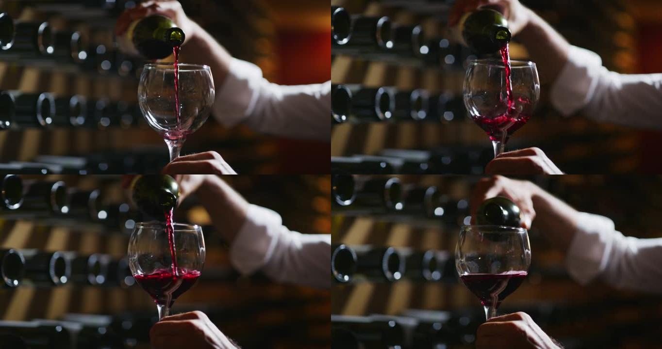 近距离拍摄酿酒师或侍酒师正在检查酒窖中倒入透明玻璃杯中的红酒的质量。
