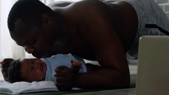 非洲父亲家庭伸展肌肉，在社交距离期间与新生儿接吻3个月时呆在家里，一起呆在家里预防流行病。在没有传统