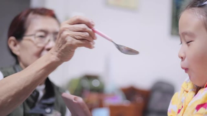 亚洲家庭祖母为孙女喂养食物
