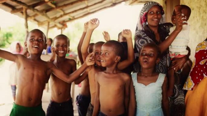 一群非洲孩子，在农村嬉笑跳跳。黑人孩子快乐地庆祝生活。镜头捕捉了童年的美丽和本质，村庄生活的天真和纯