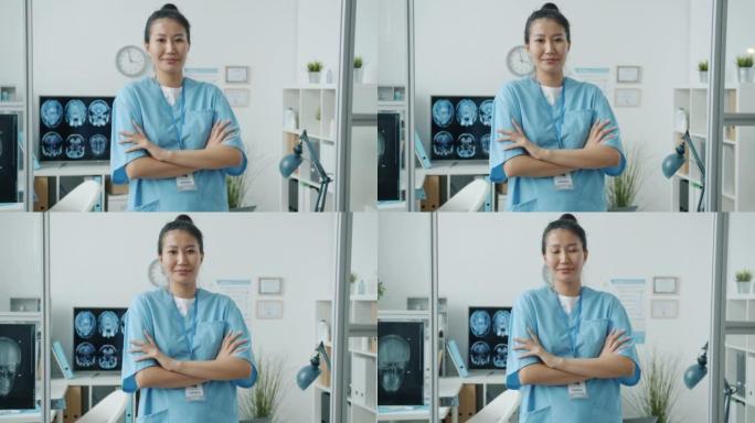 站在医院办公室微笑着的年轻亚洲妇女的慢动作肖像
