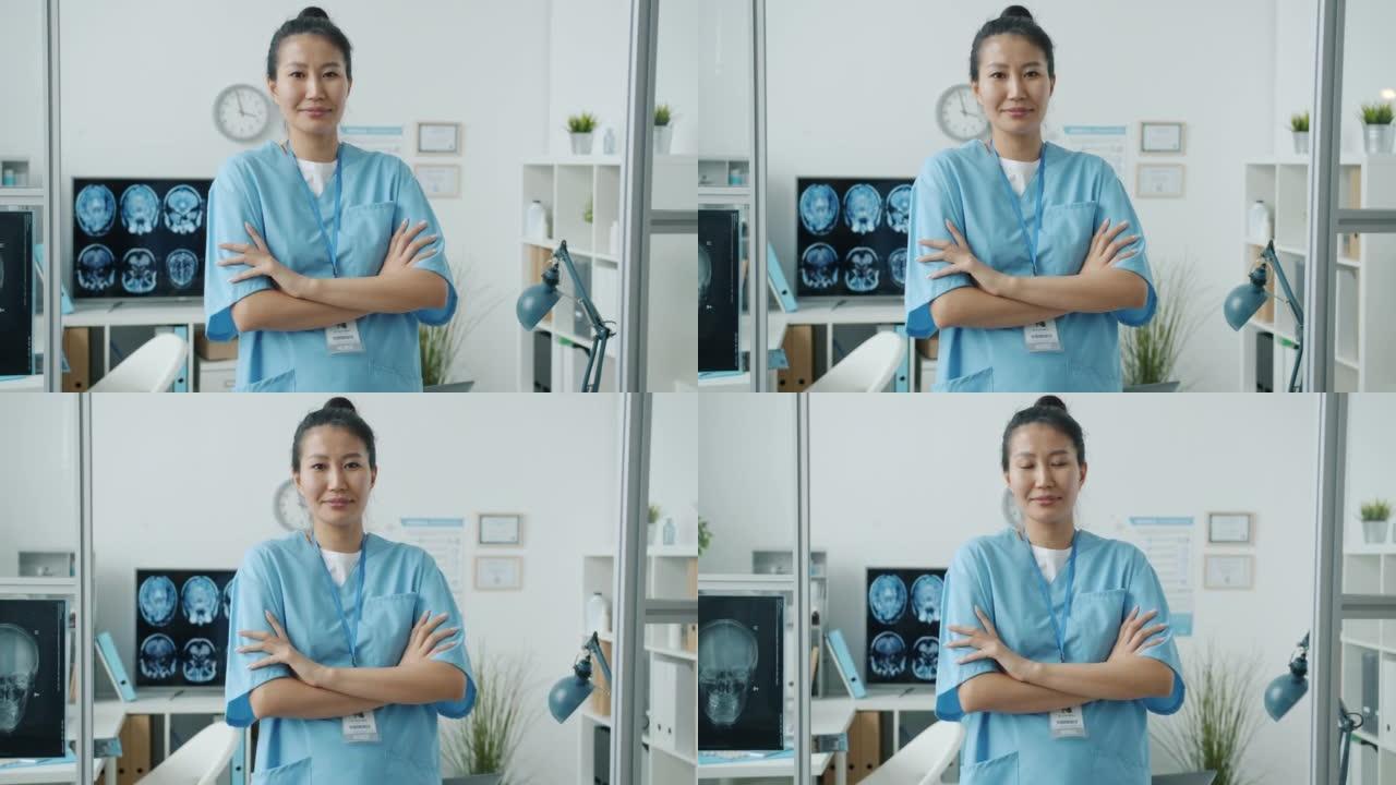 站在医院办公室微笑着的年轻亚洲妇女的慢动作肖像