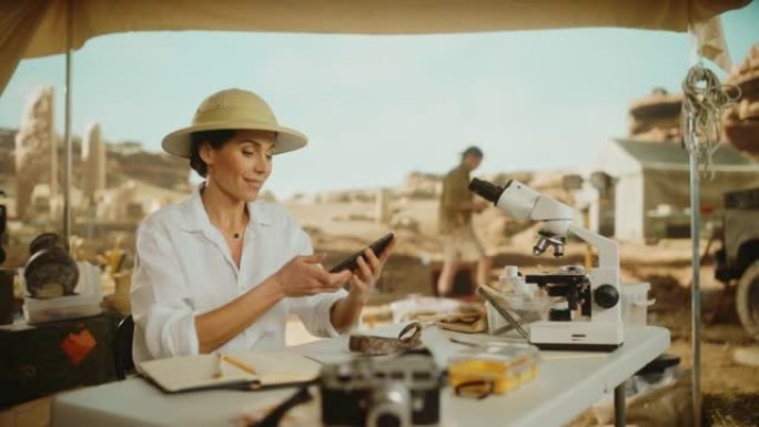 考古挖掘地点: 伟大的女性考古学家进行研究，使用智能手机在互联网社交媒体上分享化石遗骸的发现，古代文