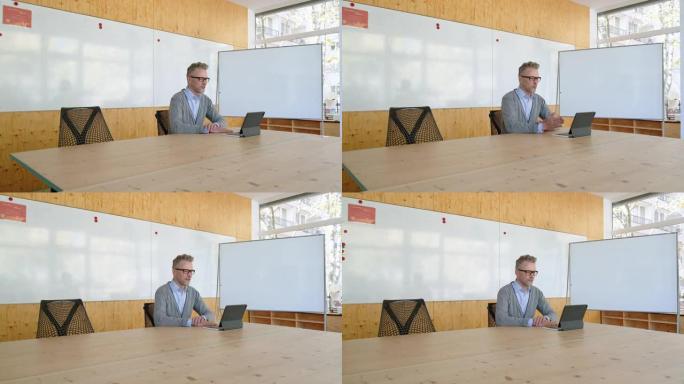 成熟的初创公司首席执行官在办公室通过数字平板电脑进行视频会议